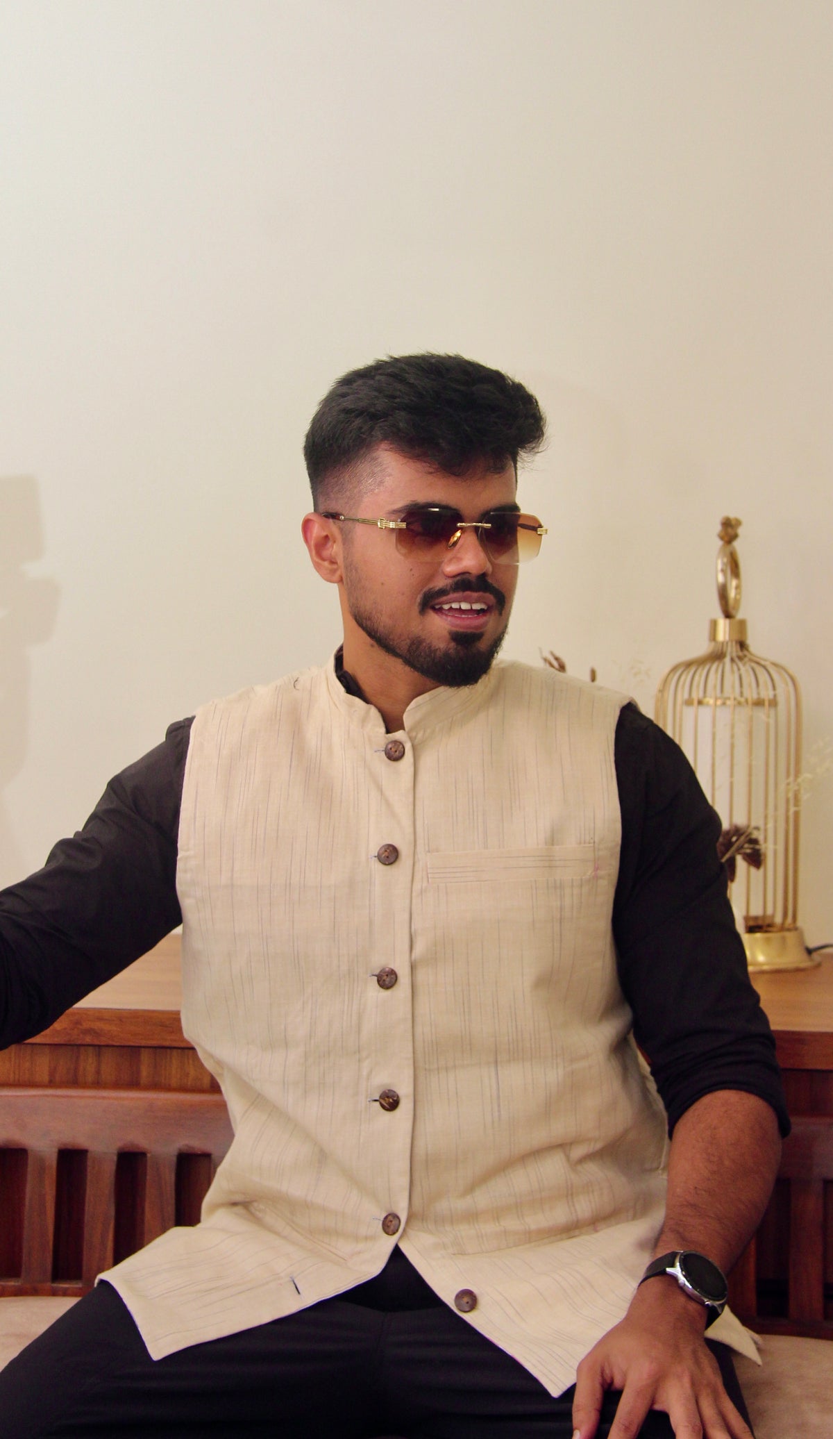 Sagar Kinaare reversible handloom jacket for men, cream reverse side worn over a black shirt, seated