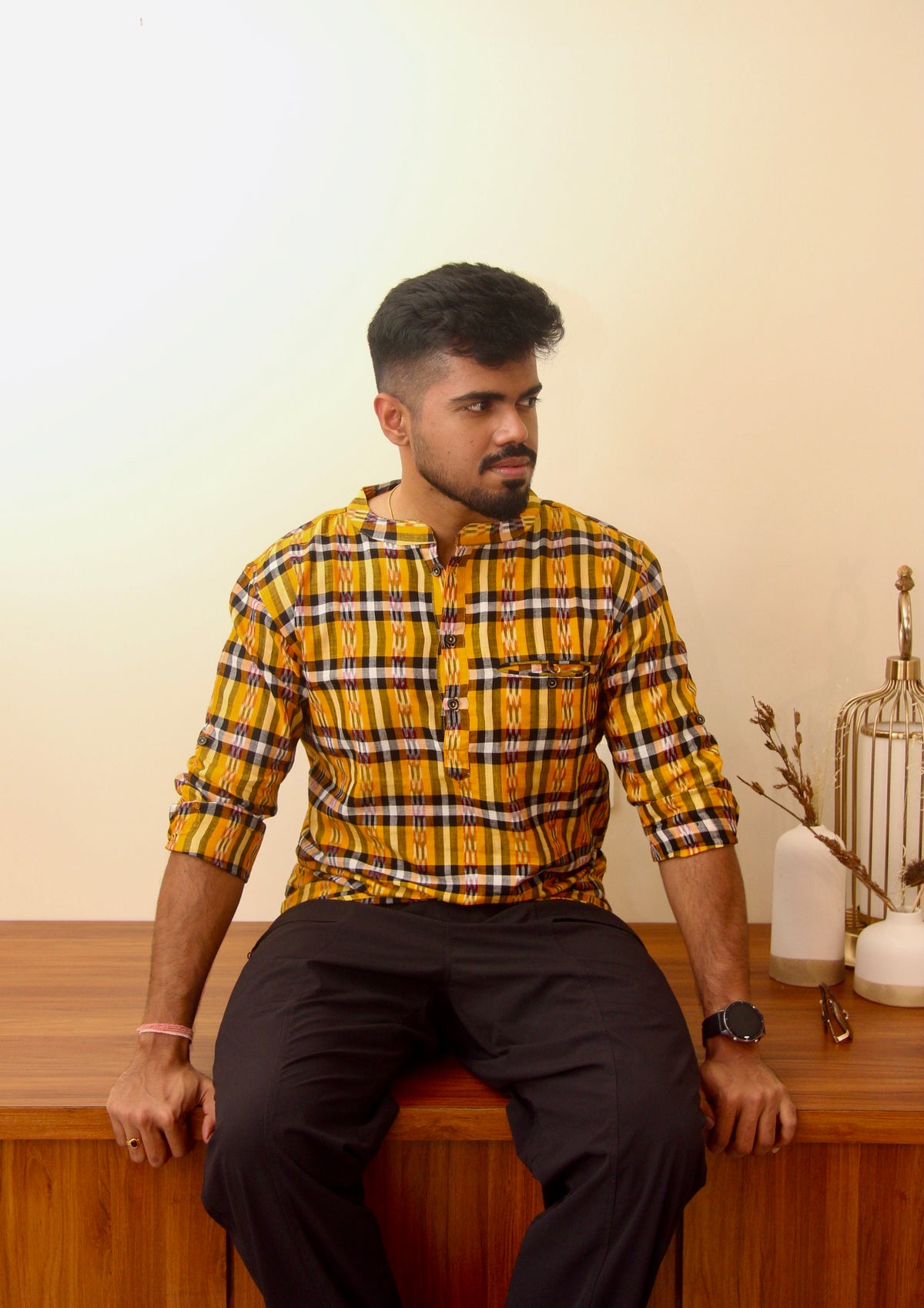 Kaali Peeli yellow and black checked Sambalpuri ikat handloom kurta for men, seated three-quarter view