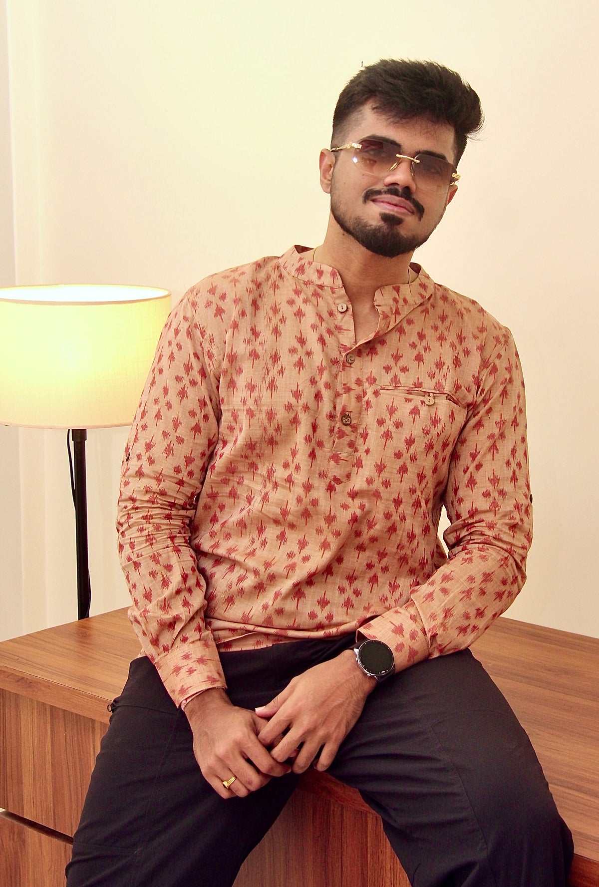 Mitti di Khushboo terracotta Nuapatna ikat handloom kurta for men worn with black trousers, seated