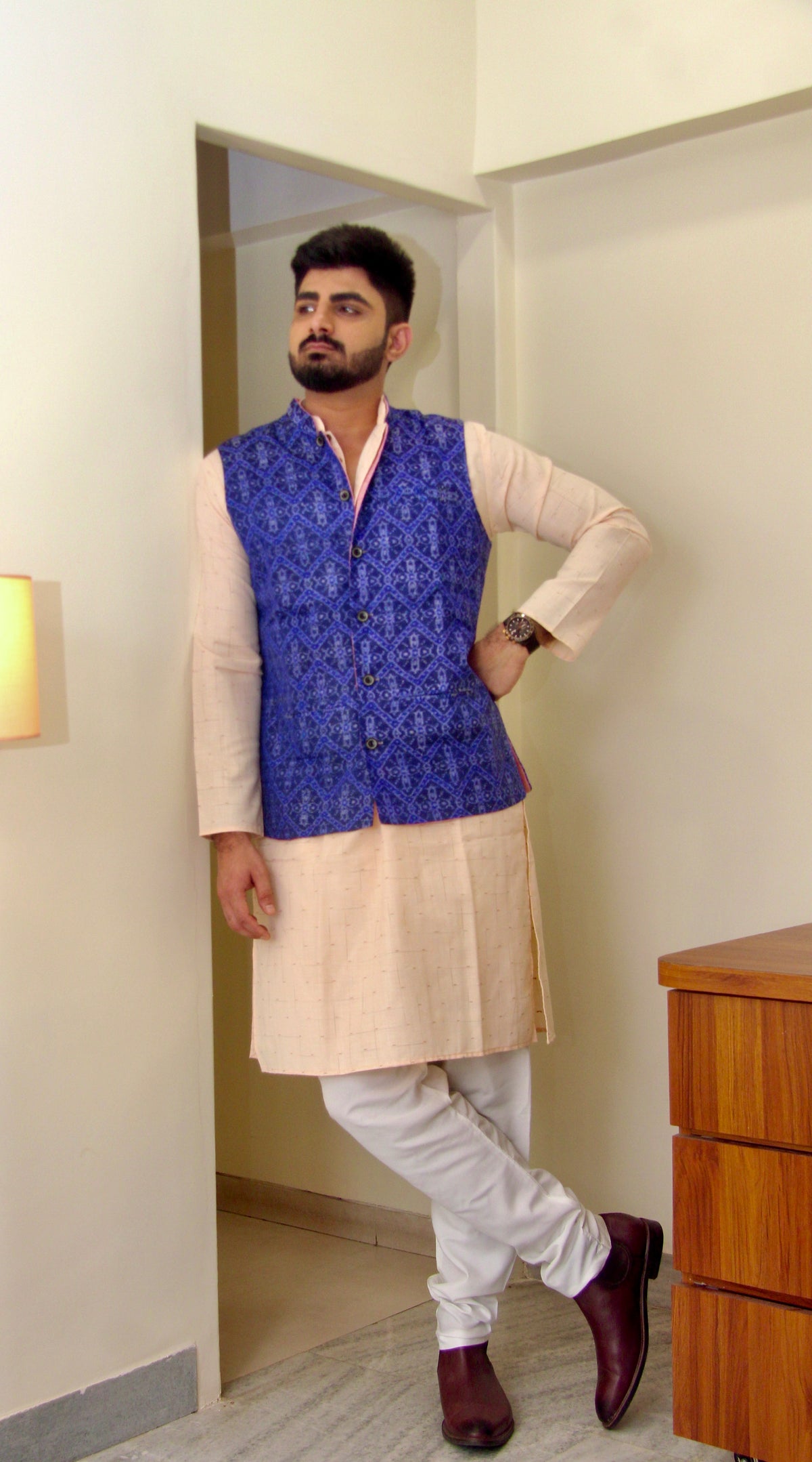 Shaam Savera reversible handloom jacket for men, blue ikat side worn over a cream kurta, full length
