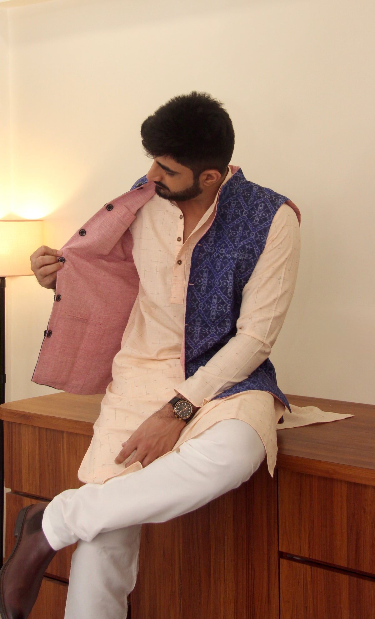 Shaam Savera reversible handloom jacket for men, blue ikat side, seated three-quarter view