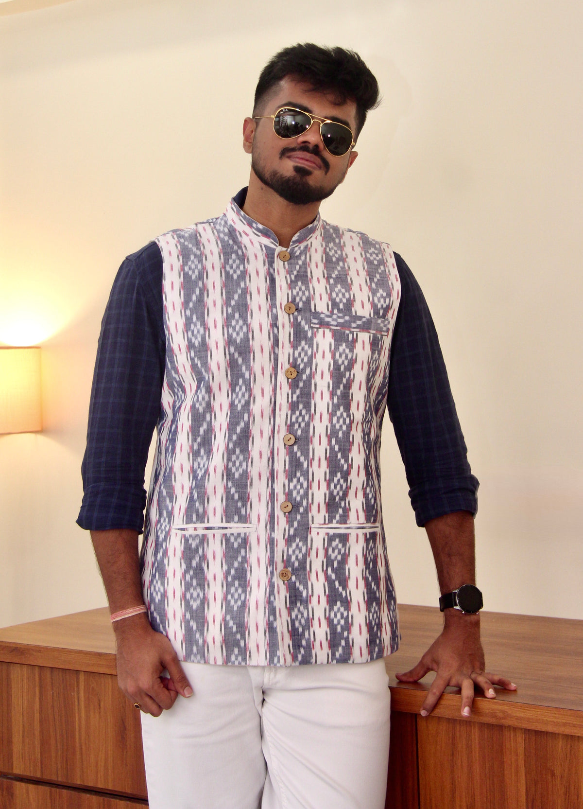 Sagar Kinaare reversible handloom jacket for men, blue ikat side worn with white trousers, standing