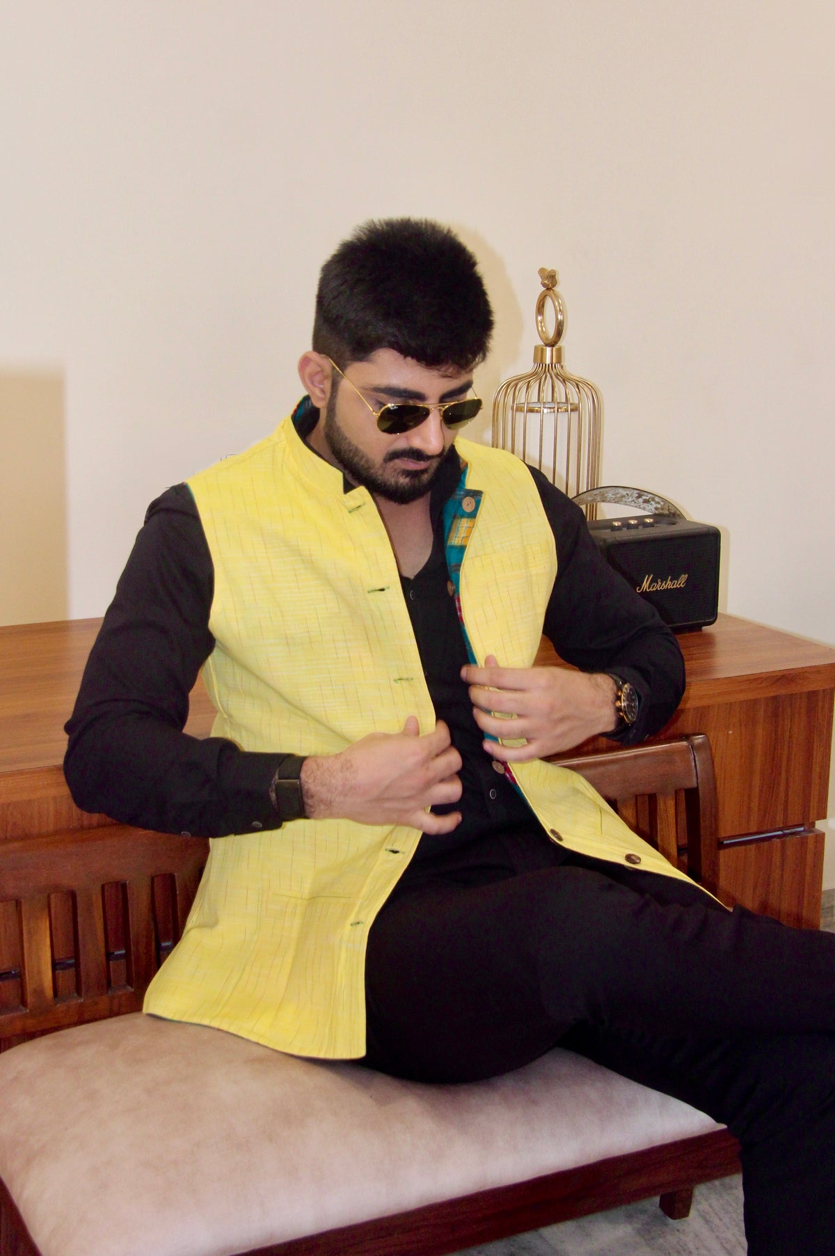 Kacchi Keri reversible handloom jacket for men, yellow reverse side, seated fastening the buttons