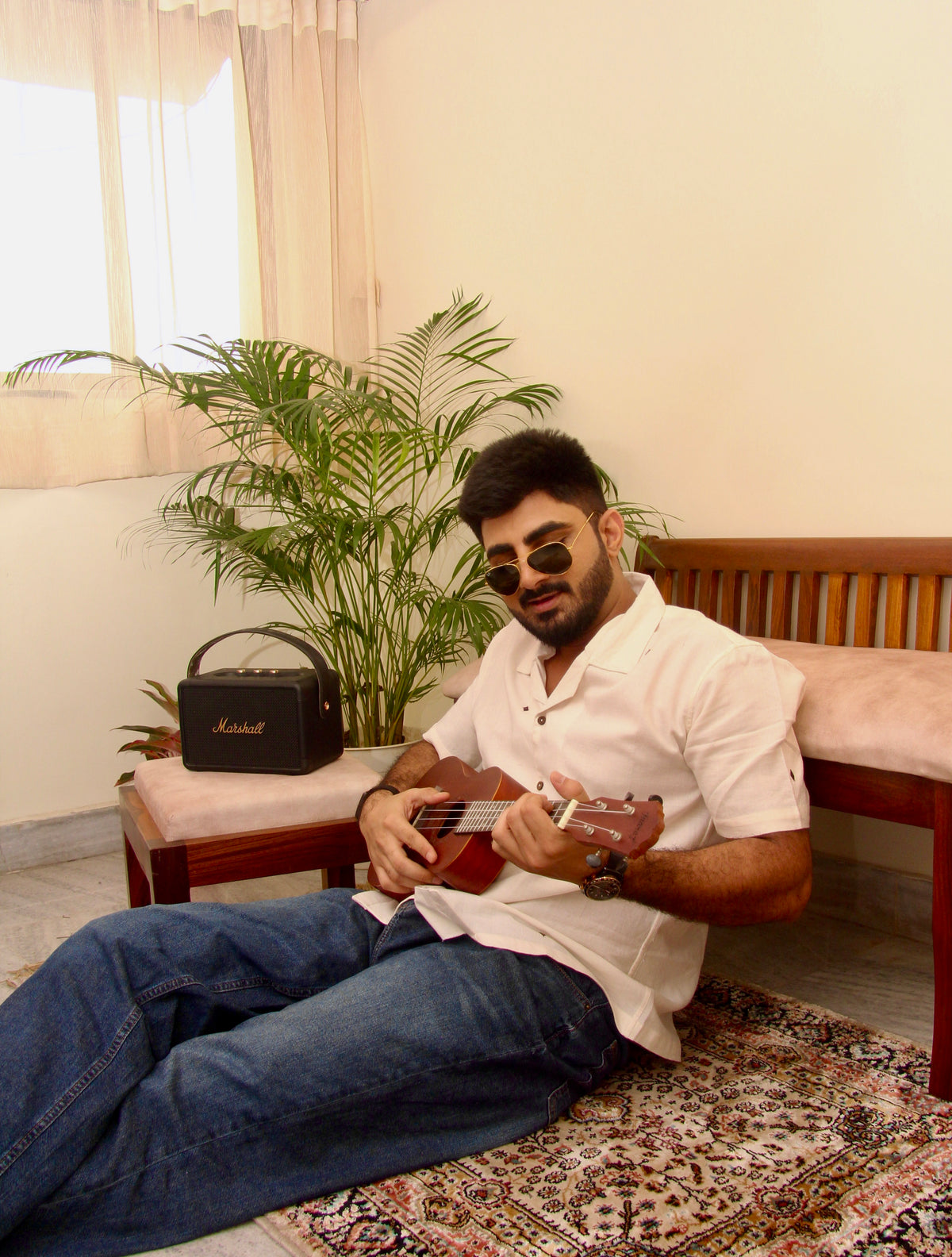 Shwet off-white Kotpad handloom shirt for men, seated with a ukulele