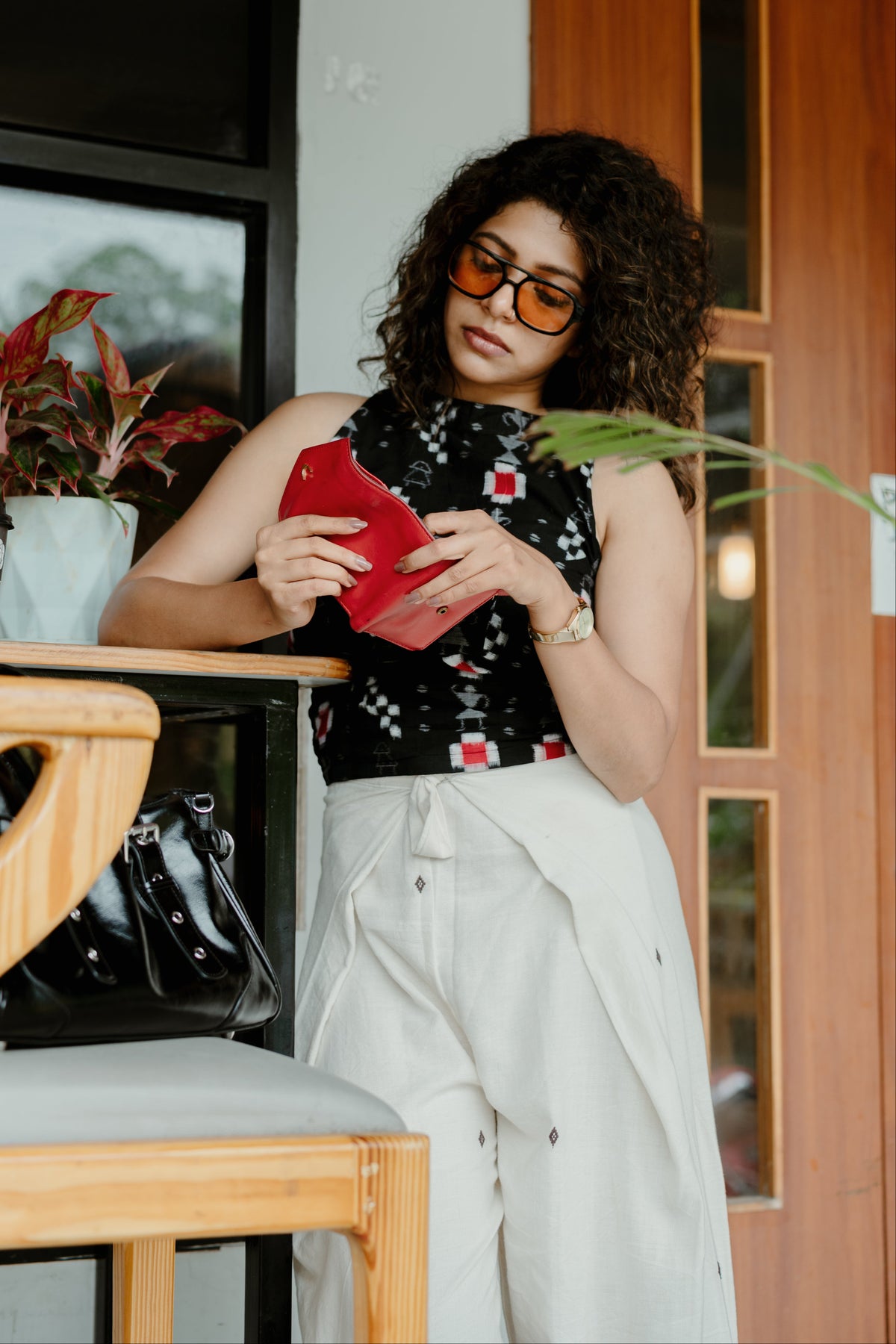 Baisali cream Kotpad handloom tie-on trousers styled with a black halter top, seated